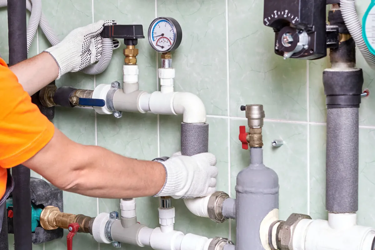 Instalatér při montáži vodovodního rozvodu